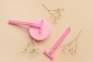 Razors for hair removal and jar of cosmetic product on color background