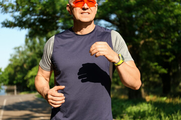Fototapeta premium Sporty mature man with eyeglasses running in park