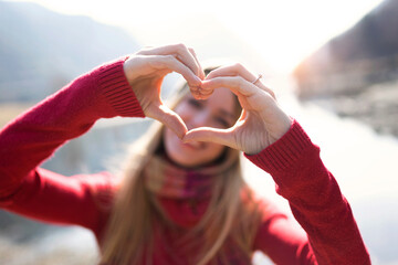 Portrait of young woman making heart shape with hands and fingers