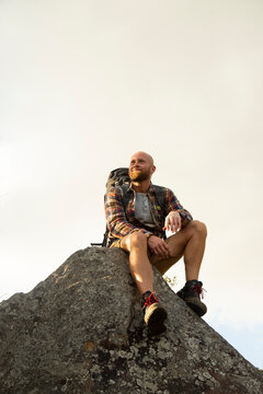 Spain, Andalusia, Tarifa, smiling man on a hiking trip having a break sitting on rock