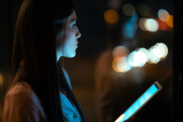 Pensive young woman with digital tablet in office