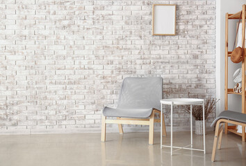 Armchair near stylish brick wall