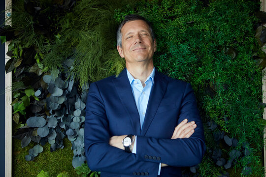 Smiling businessman with closed eyes in green office
