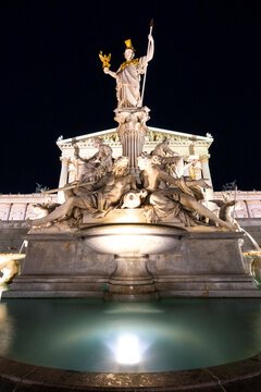 Austria, Vienna, Pallas Athena fountain in front of Parliament building illuminated at night