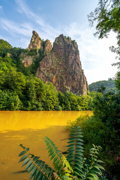 Germany, Rhineland-Palatinate, Bad Munster am Stein-Ebernburg, Yellow Nahe river with Rheingrafenstein rock formation in background