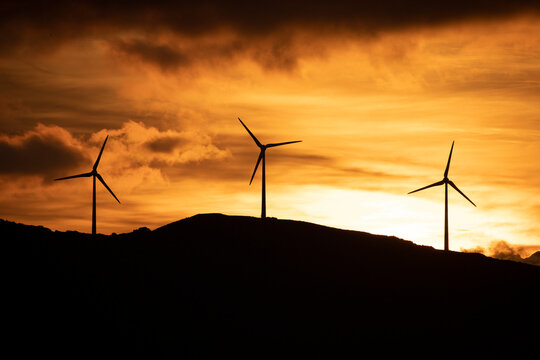 Spain, Andalusia, Tarifa, wind wheels on mountain at sunrise