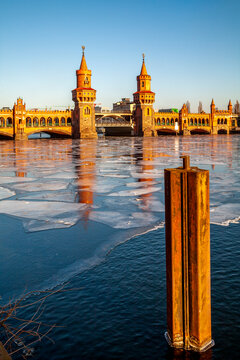 View to Oberbaum Bridge at sunset with frozen Spree River in the foreground, Berlin, Germany