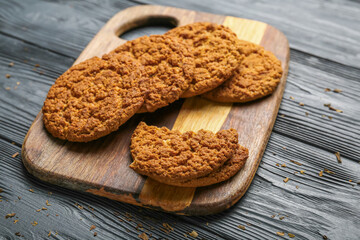 Board with tasty hojicha cookies on black wooden background