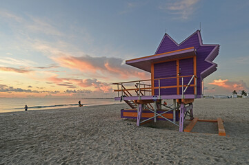 Colorful lifeguard station on Miami Beach, Florida under late summer cloudscape in early morning light.
