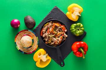 Obraz na płótnie Canvas Composition with tasty Fajita, vegetables and sombrero hat on green background
