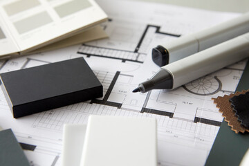 Felt tip pens and material swatches lying on architecturalÔøΩblueprint