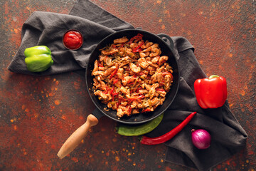 Frying pan with tasty chicken Fajita on grunge background