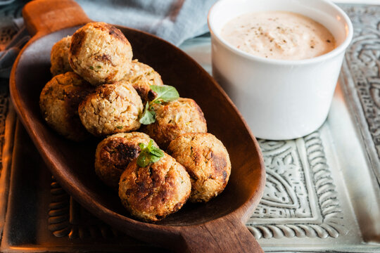 Fried oat balls with tomato sauce and bowl of dipping sauce