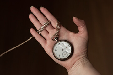 Hand of woman holding antique pocket watch