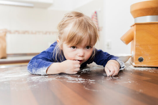 Girl playing with flour in kitchen