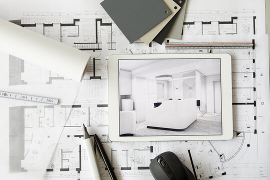 ArchitecturalÔøΩblueprints and digital tablet displaying modern showcase interior
