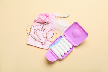 Composition with tampons storage box and female jewelry on beige background