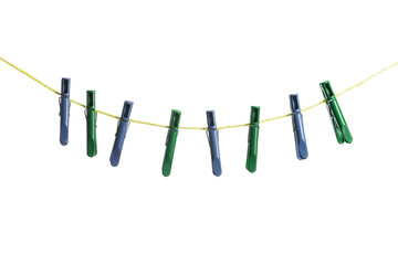 Plastic clothespins hanging on rope against white background