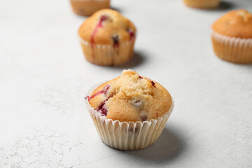 Delicious cranberry muffins on white background