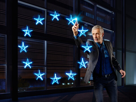 Businessman painting the stars of teh Europwan Union with light