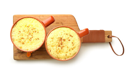 Cups of healthy turmeric latte on white background
