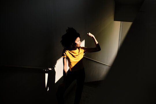 Woman showing muscles while standing on steps