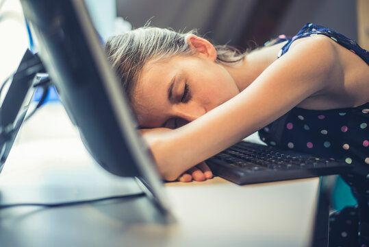 Germany, Brandenburg, Teenage girl falling asleep while using computer