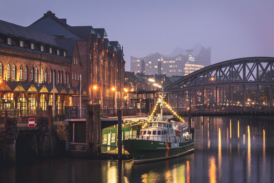 Germany, Hamburg, Boat moored in front of bridge over Elbe canal with Elbphilharmonie in background