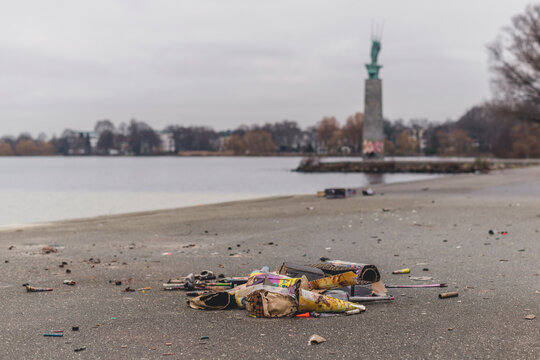 Germany, Hamburg, Garbage lying on sandy shore of Outer Alster Lake
