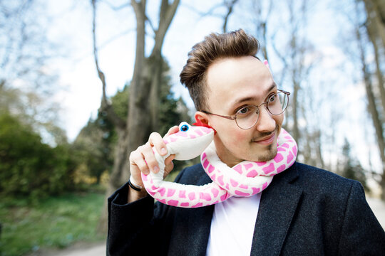 Young man wearing toy snake around his neck