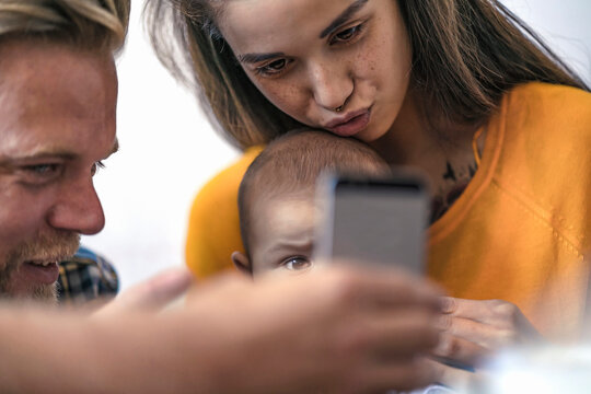 Family with baby using cell phone