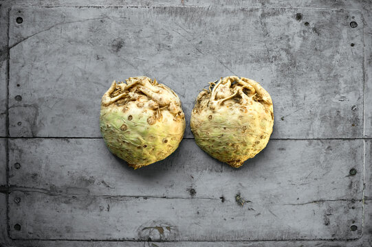 Halved celeriac lying on gray wooden surface