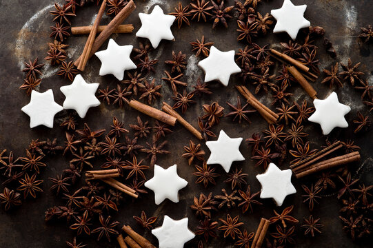 Cinnamon star cookies, cinnamon sticks and star anise on rustic baking sheet