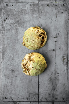 Halved celeriac lying on gray wooden surface