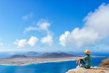 Man on viewpoint looking to La Gracioas island from Lanzarote, Canary Islands, Spain