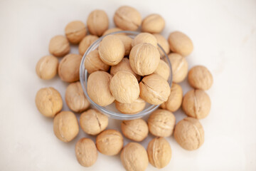 A lot of whole walnuts in a cup on a white background close-up. Healthy, organic food with a high content of protein and protein.