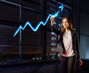 Businesswoman painting the stock market development with light