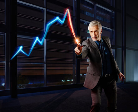 Businessman painting the stock market development with light
