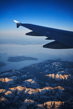 France, Auvergne-Rhone-Alpes, Wing of Airbus A321 flying over European Alps and Lake Geneva at dawn