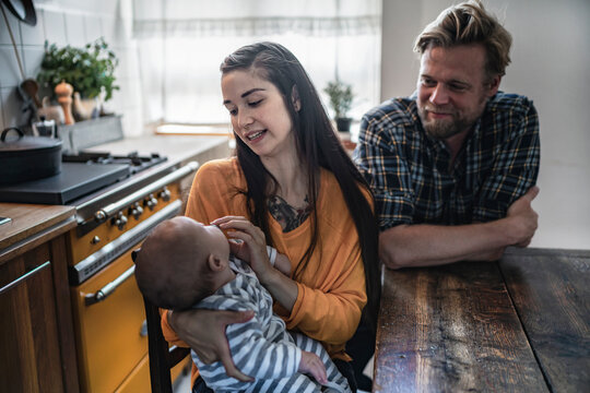 Family with baby sitting at kitchen table at home