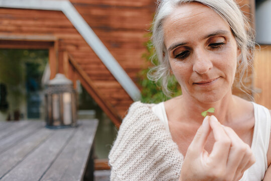 Portrait of woman looking at cloverleaf