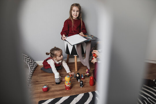 Mother and two girls playing in children's room at home