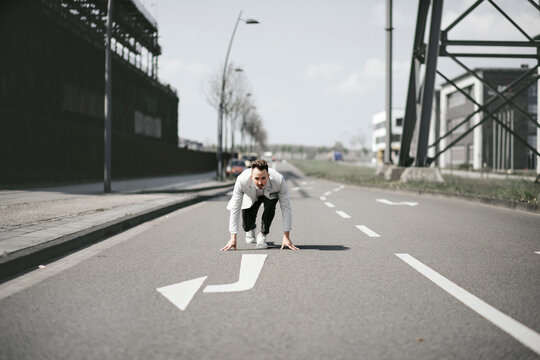 Businessman in starting position on a road with arrow