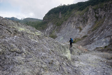 Naklejka premium photo of sulfur hills and you see someone with a blue bag