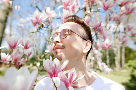 Young man enjoying magnolia blossom