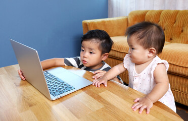 パソコンの画面を見ている二人の子供。兄と妹。
