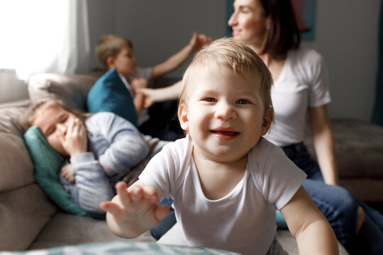 Portrait of happy baby boy with his family on couch in living room at home