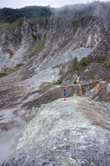 portrait photo, sulfur mine, seen from a distance a person in a blue shirt