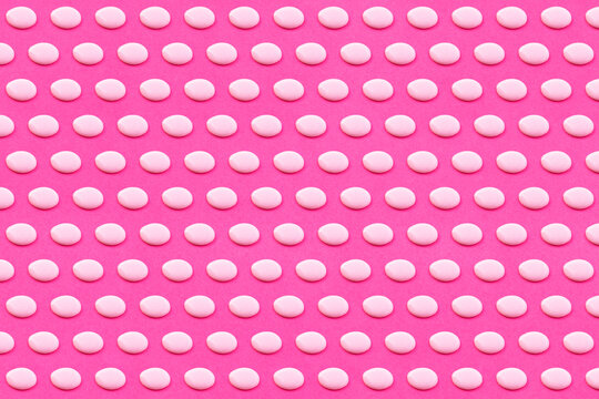 Pattern of white liquid drops against vibrant pink background