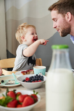 Little boy with father having fun at breakfast table